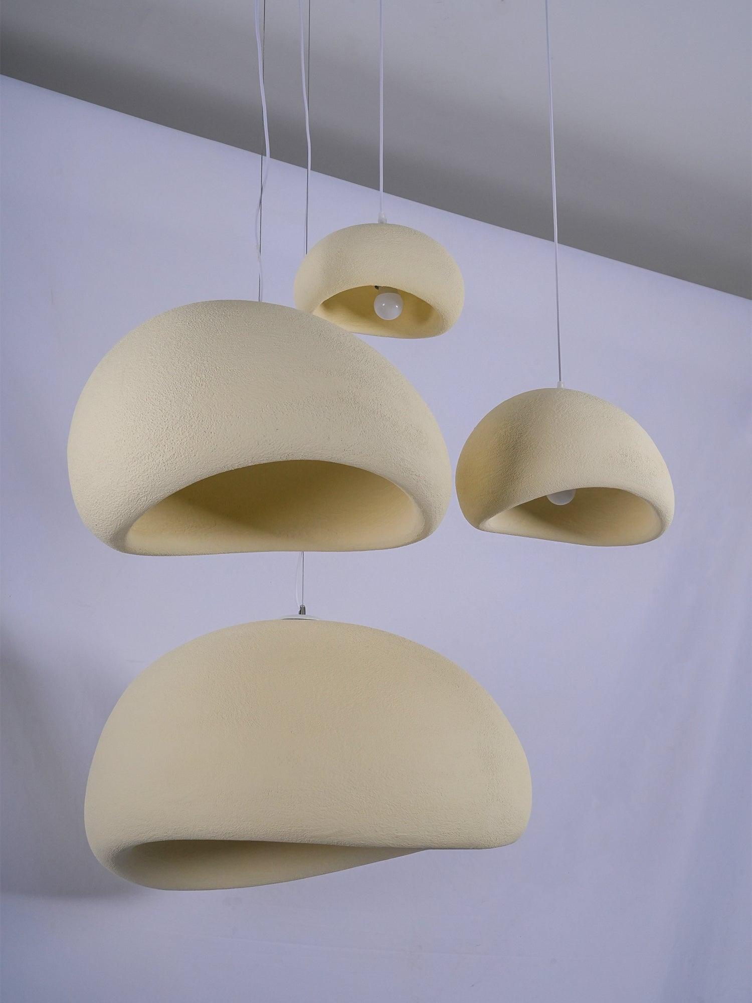 Wabi-sabi organic chandelier pendant lit with a warm globe