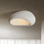 Against a shadowed studio backdrop, this Clérachic ceiling light glows in its white texture finish.