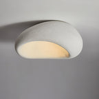 Angled to show its curve, this Clérachic ceiling light glows in its white texture finish against plain grey.