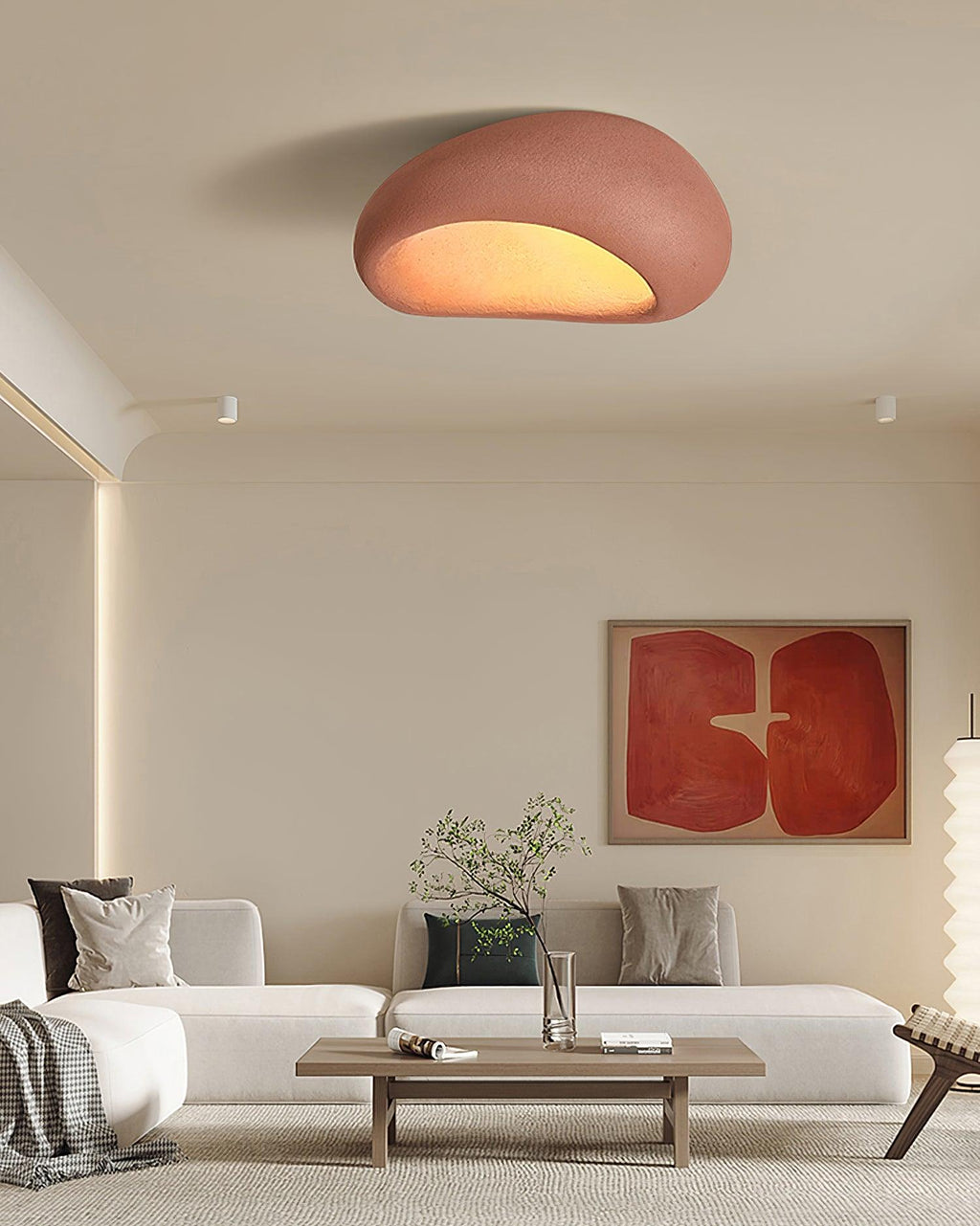 In brick red, this Clérachic ceiling light glows above a white sofa and a red abstract art print.