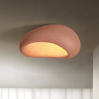 In brick red, this Clérachic ceiling light glows against a shadowed studio backdrop.