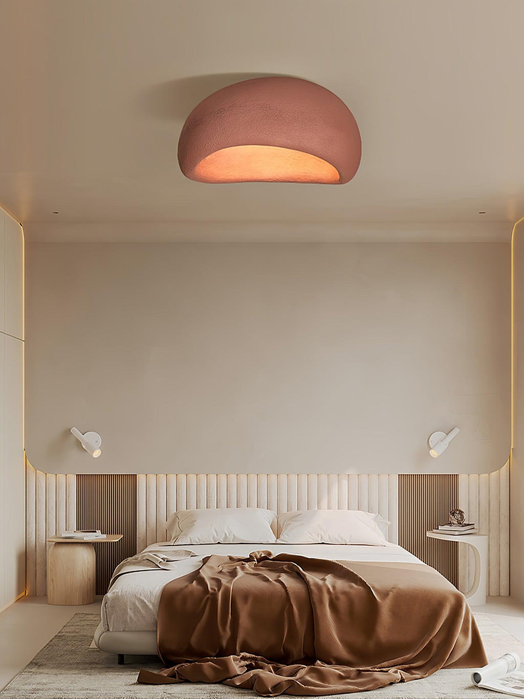 Dressed with a rust-toned throw below, the bed sits under this Clérachic ceiling light glowing in brick red.