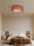 Dressed with a rust-toned throw below, the bed sits under this Clérachic ceiling light glowing in brick red.