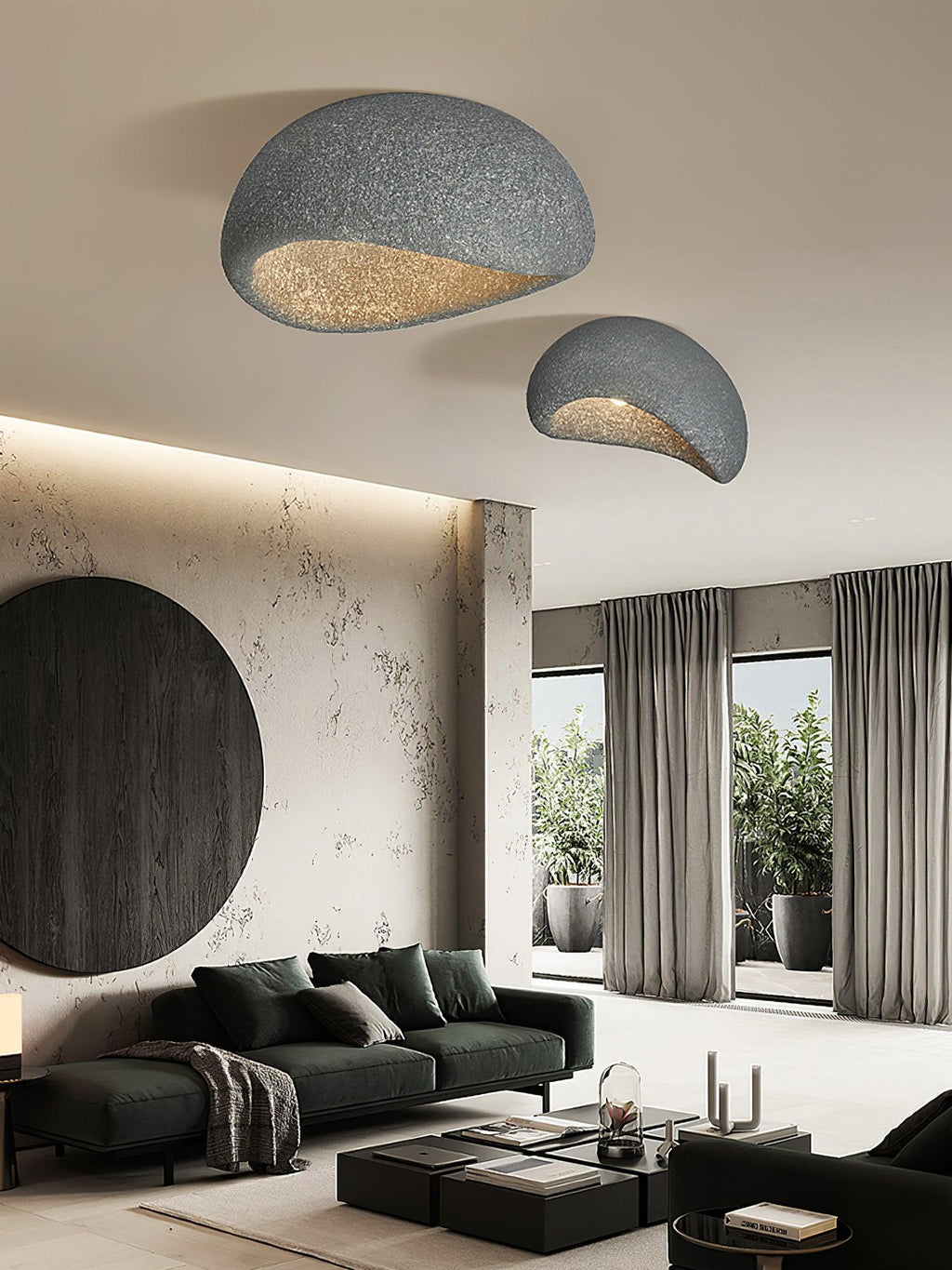 Two sizes in a dark speckled finish, this Clérachic pair glows above a green sofa and a curved dark wall feature.