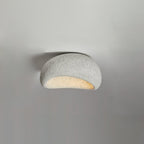 A small size of this Clérachic ceiling light in a light speckled finish glows against plain grey.