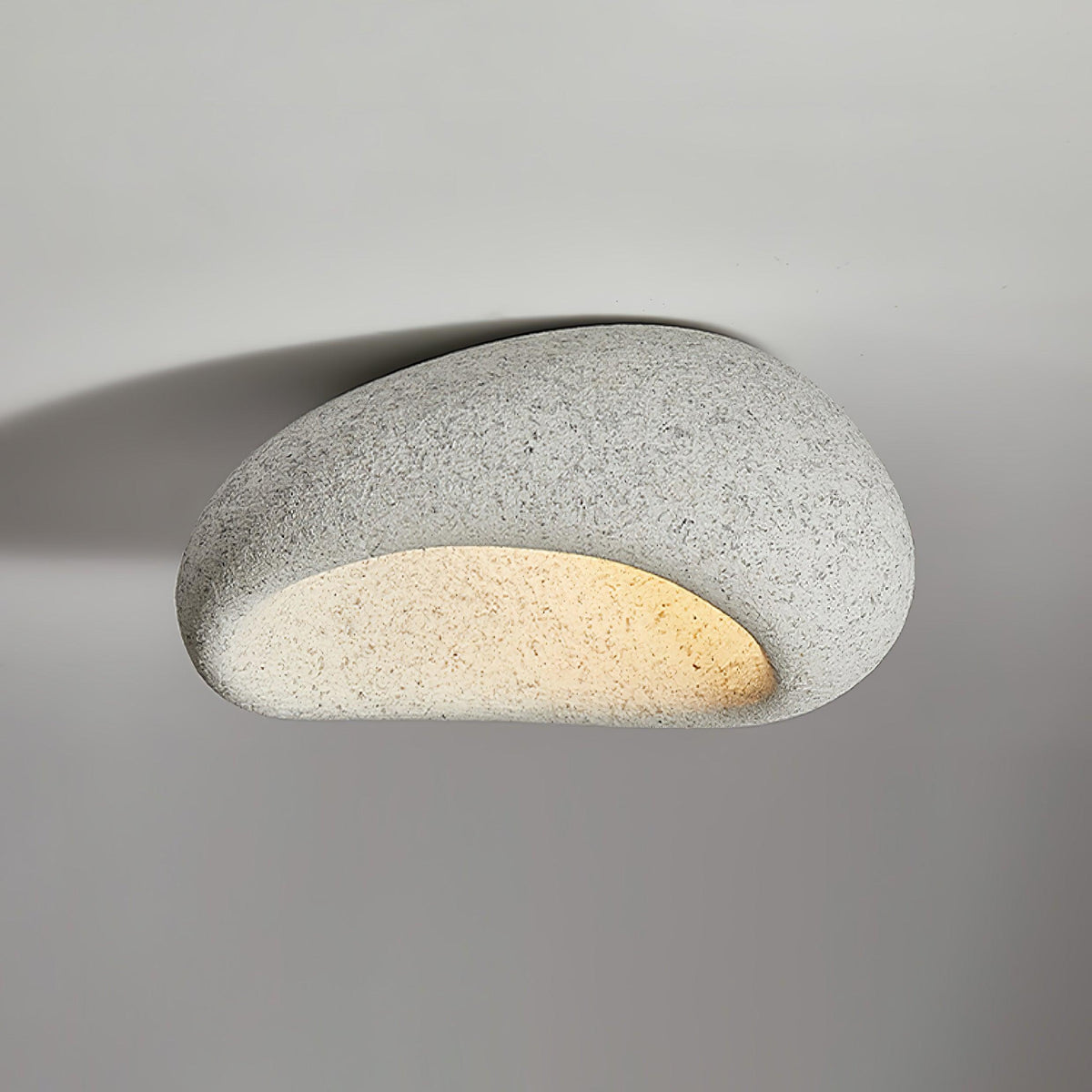 A larger size of this Clérachic ceiling light in a light speckled finish glows against plain grey.