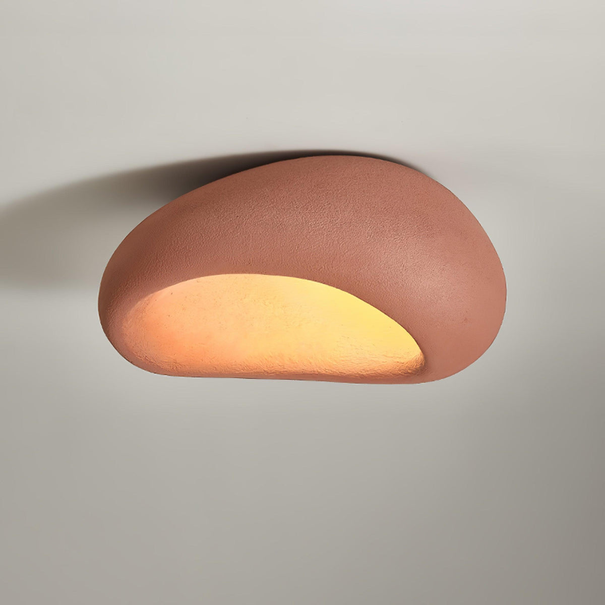 In brick red, this Clérachic ceiling light glows against a plain grey background.