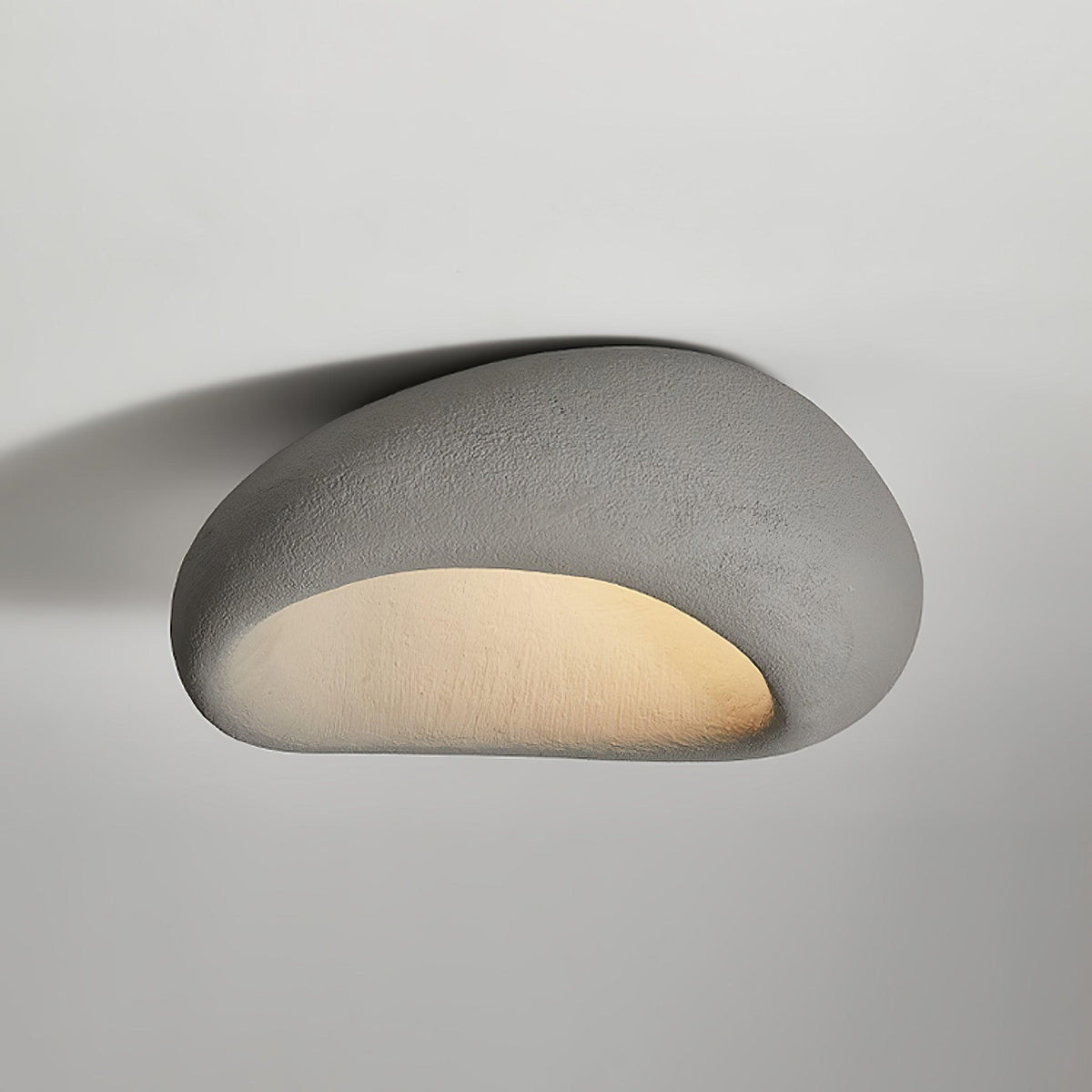 A smooth cement-grey finish glows on this Clérachic ceiling light against a plain grey background.