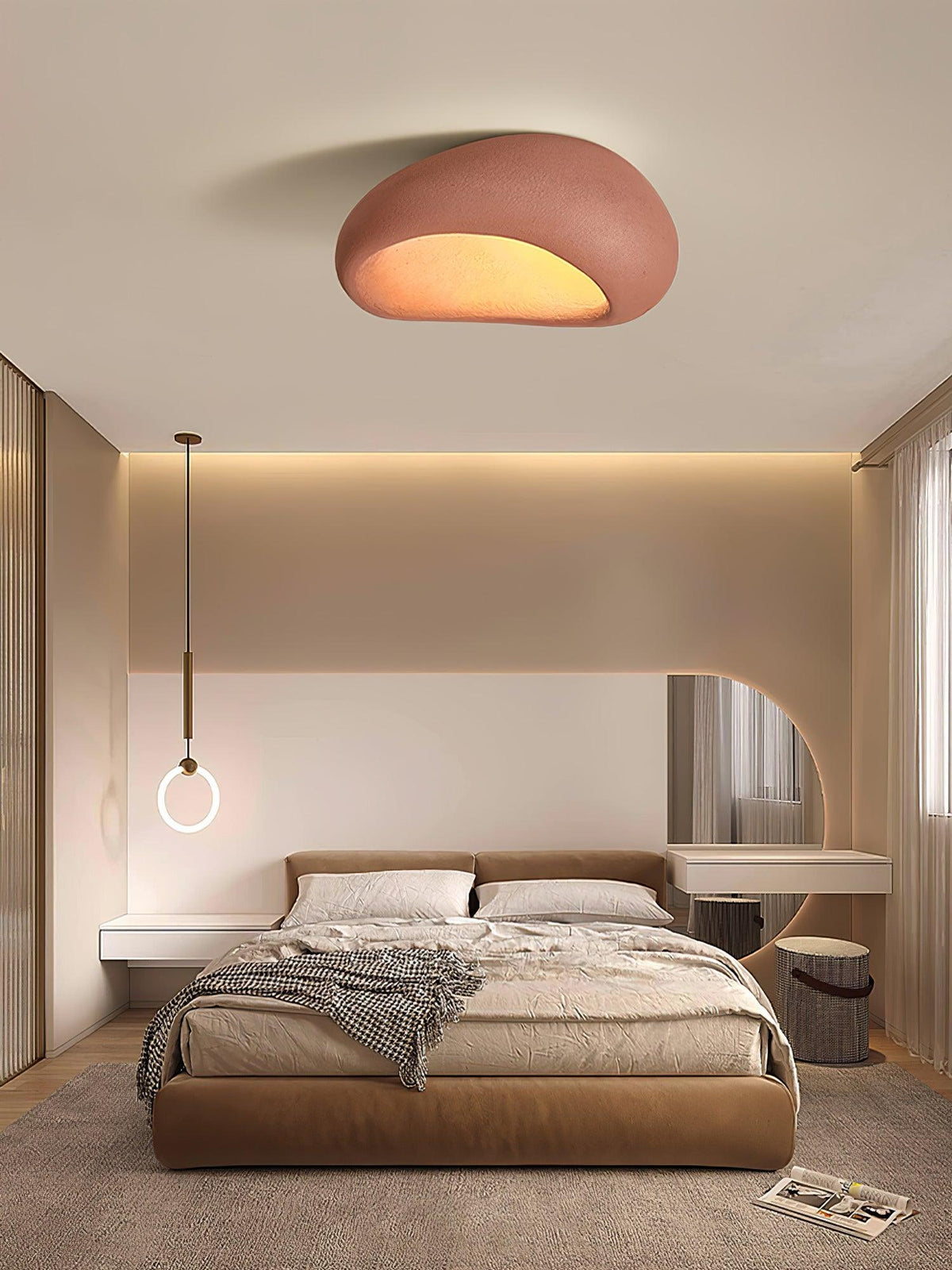 In brick red, this Clérachic ceiling light glows above a bedroom with a ring pendant lamp and round mirror.