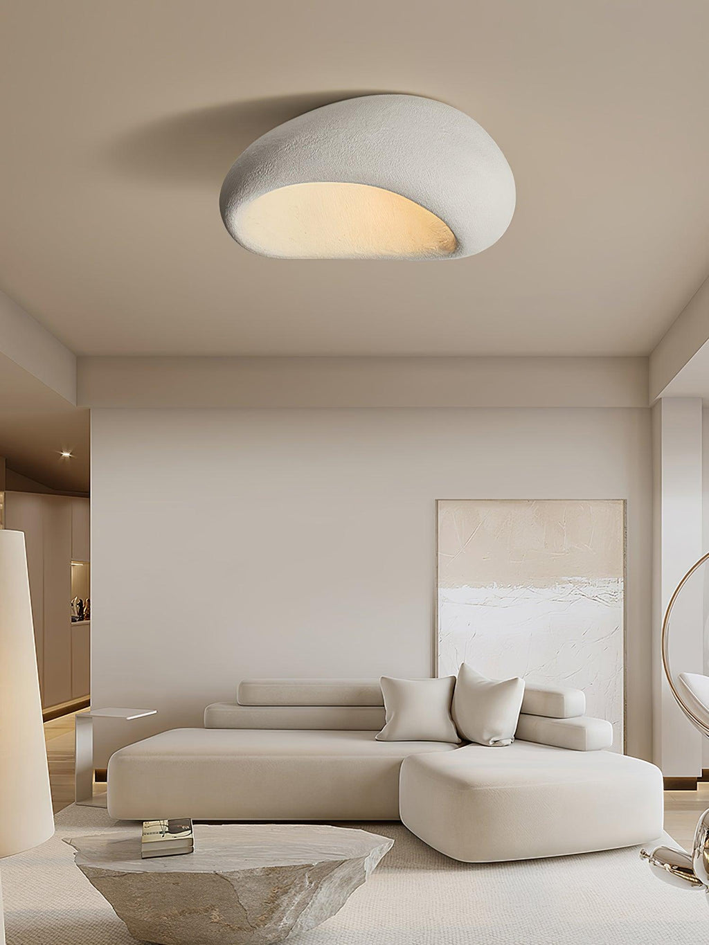 This Clérachic ceiling light glows above a beige sectional sofa and a rough stone side table.