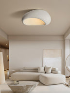 This Clérachic ceiling light glows above a beige sectional sofa and a rough stone side table.