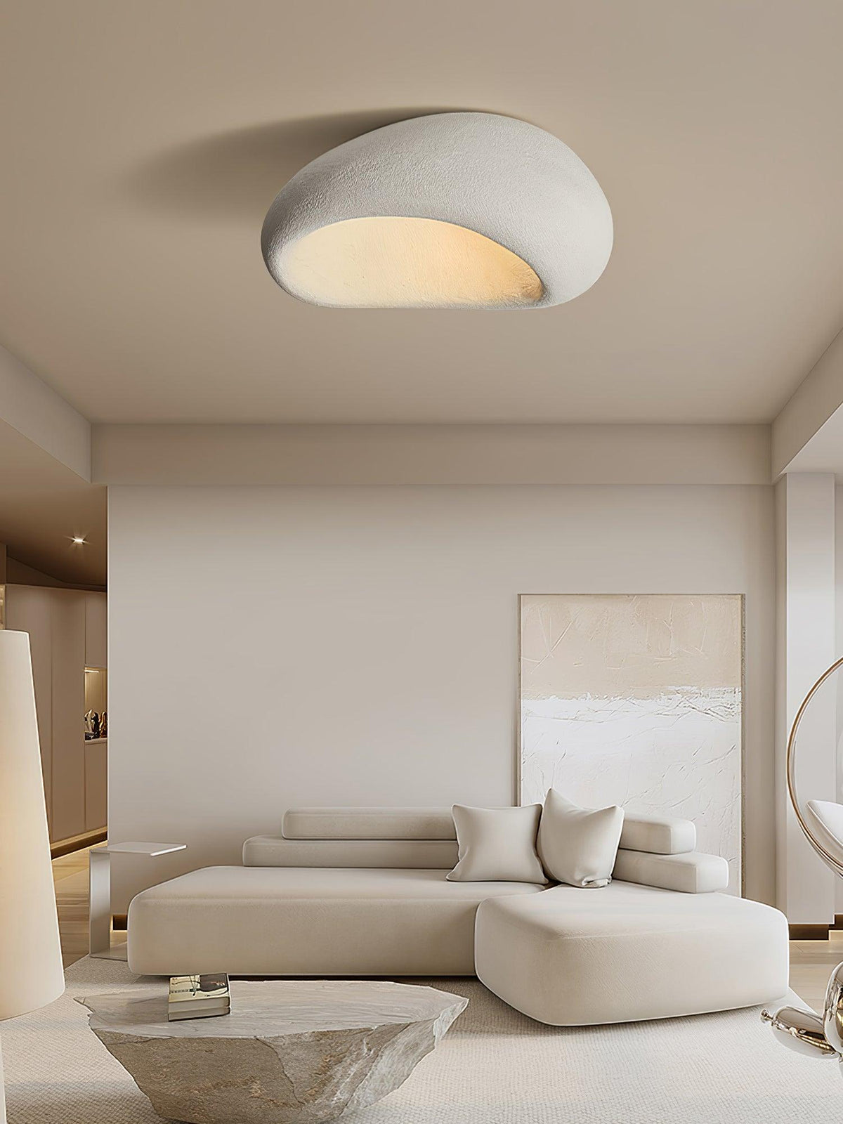 This Clérachic ceiling light glows above a beige sectional sofa and a rough stone side table.
