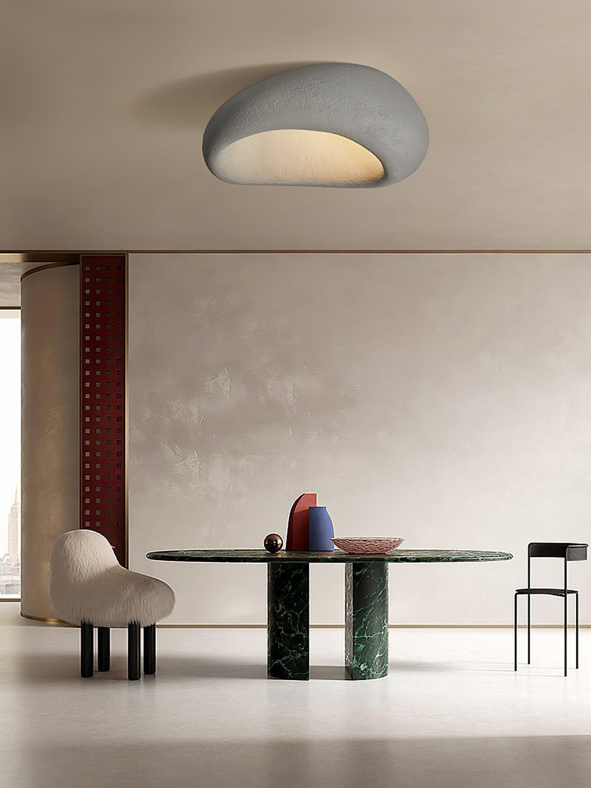 Above a dining table with a green marble base, this Clérachic ceiling light glows in cement grey.