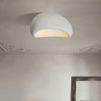 Beneath a decorative cornice, this Clérachic ceiling light glows in white texture, a mirror frame leaning against the wall.