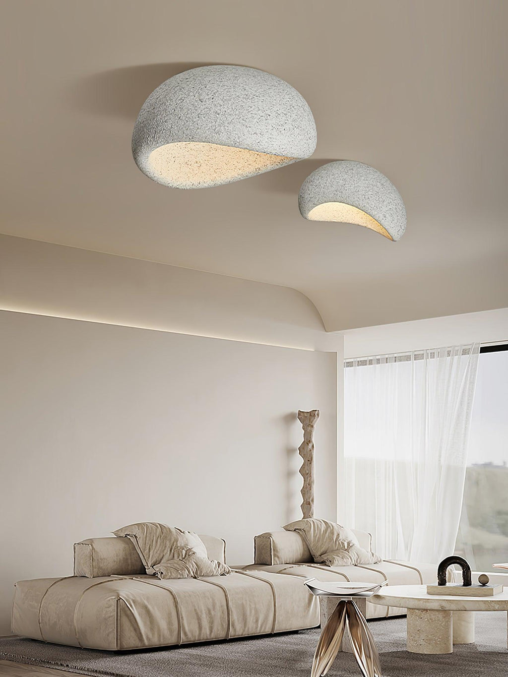 Two sizes of this Clérachic ceiling light glow above a living room with a sheer curtain and a sculptural floor lamp.
