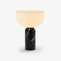 Clérachic touch-control table lamp with a warm white dome shade rising from a polished black marble cylinder, shown on a plain studio backdrop.