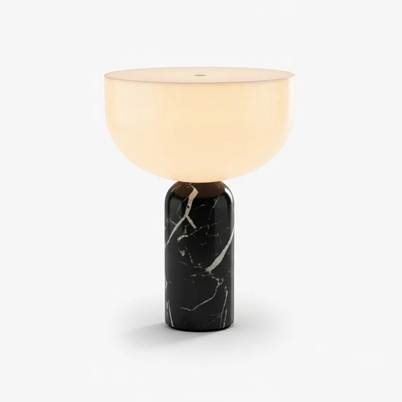 Clérachic touch-control table lamp with a warm white dome shade rising from a polished black marble cylinder, shown on a plain studio backdrop.