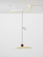 Swing arm pendant light with slim lit disc over a studio desk