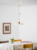 Dark red swing arm pendant light with slim lit acrylic disc