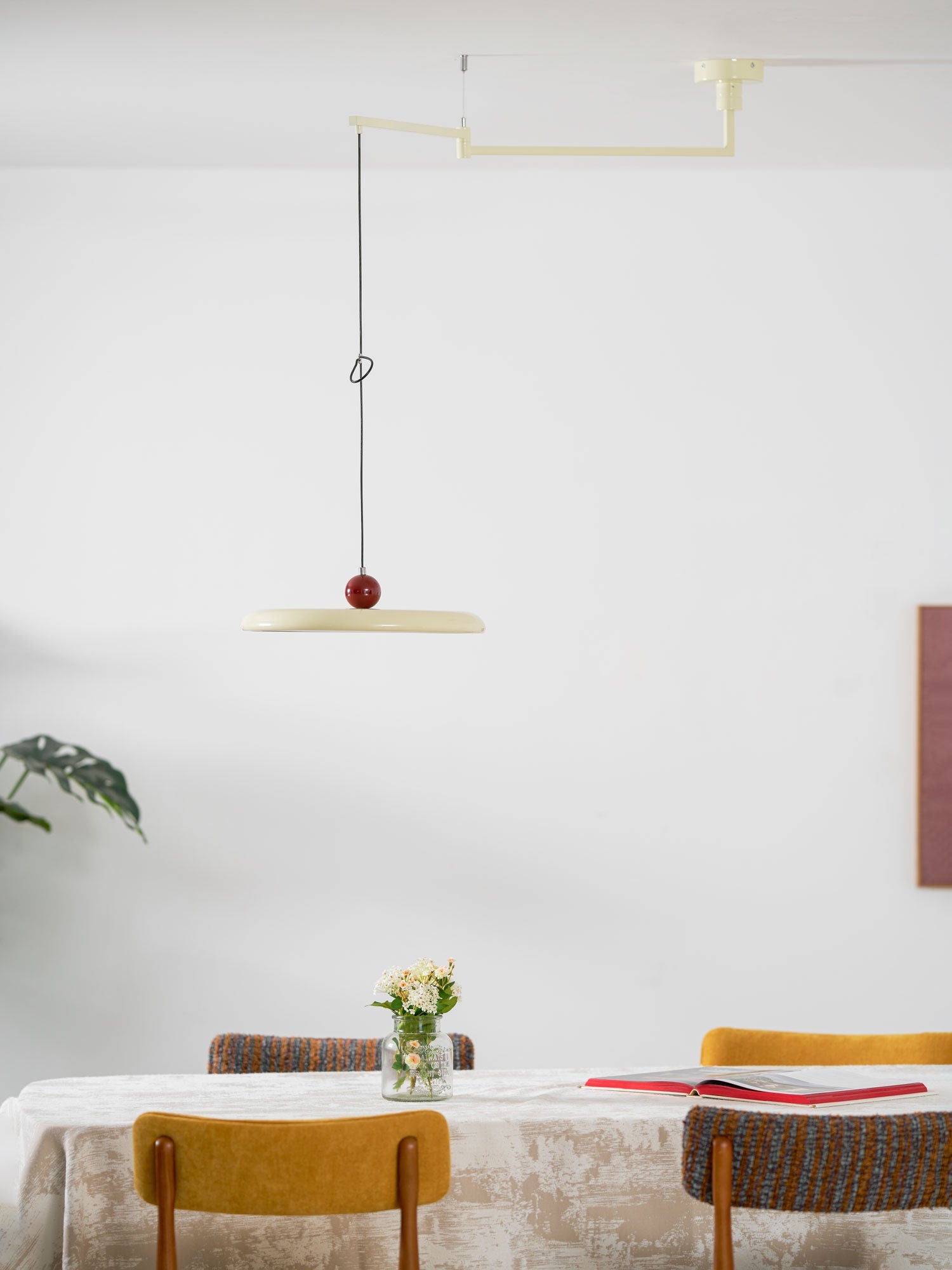Disc pendant light on a swing arm with contrasting counterweight