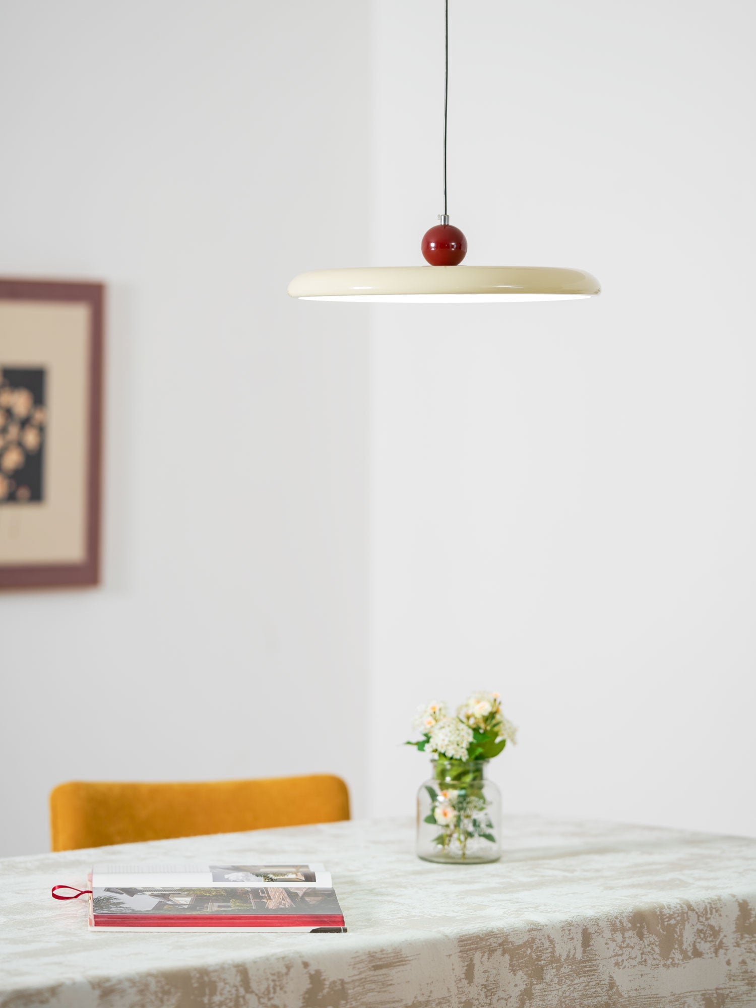 Mid-century pendant light with lit disc balanced by a round weight