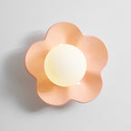 Close studio shot of this Clérachic wall light in pink with its ball lit, against a plain grey backdrop.