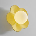 Warmer in tone, this Clérachic wall light in golden yellow glows against a plain grey backdrop.