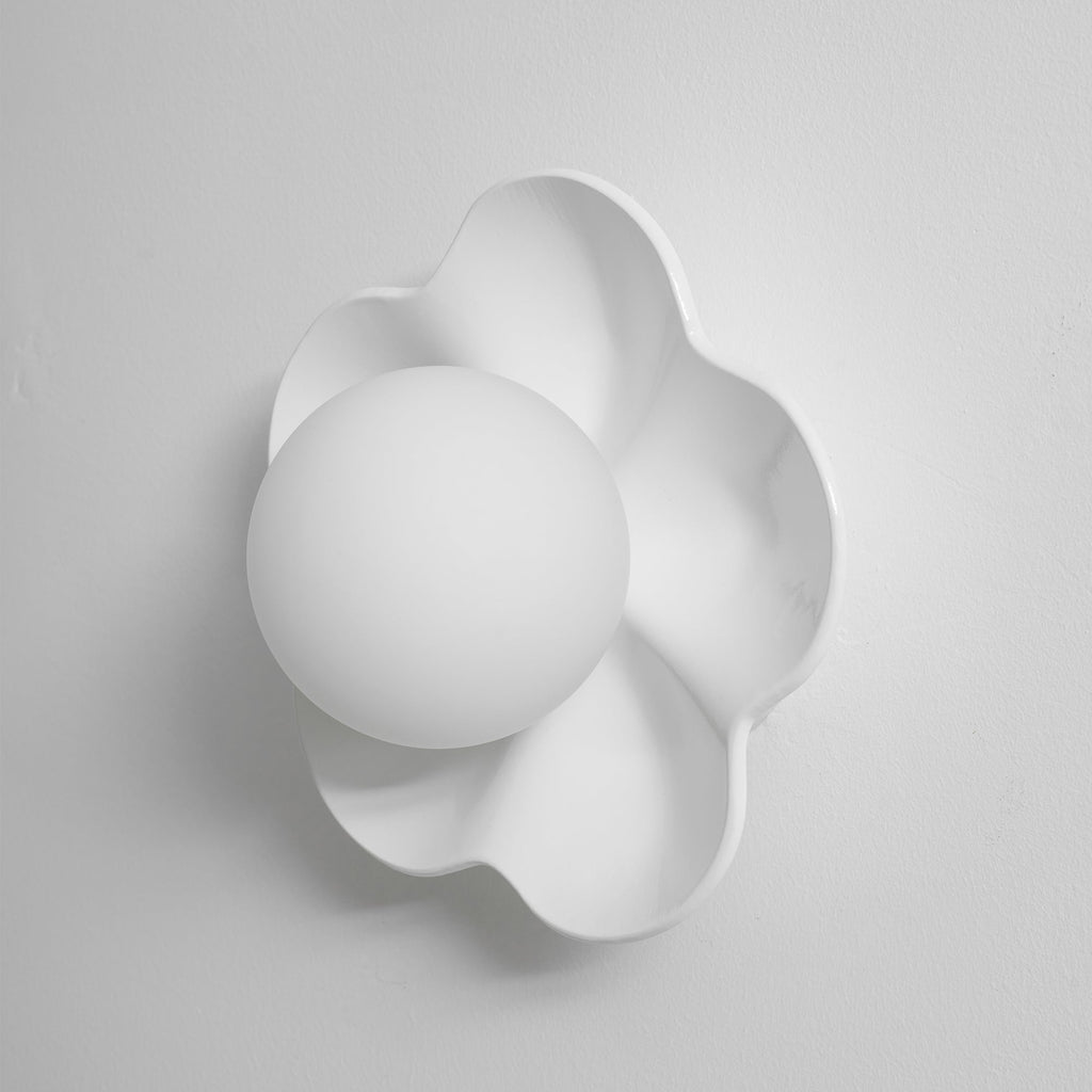 With a soft shadow cast to the left, this Clérachic wall light in white sits unlit against a plain backdrop.