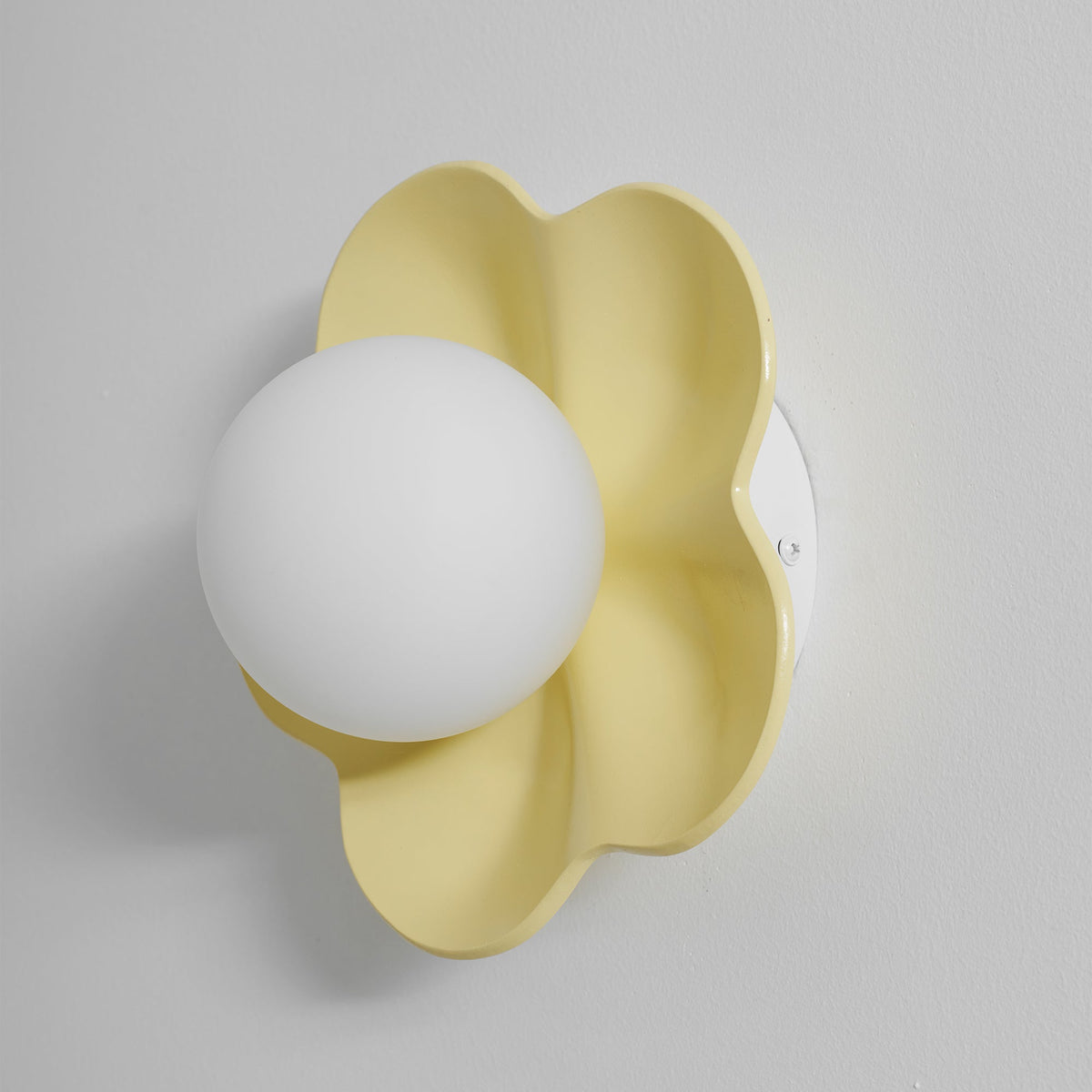 Mounted close against the wall with its ball unlit, this Clérachic wall light in yellow fills the frame.