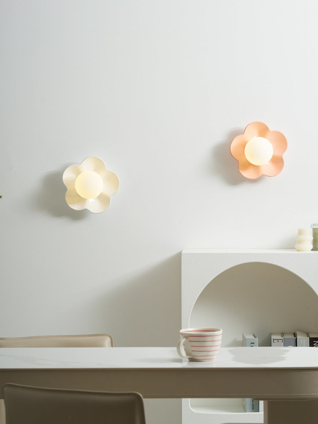 Two of these Clérachic wall lights, in white and pink, are mounted unlit above a curved console table.