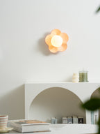 Mounted unlit above the same console table, this Clérachic wall light in pink sits beside a small candle below.