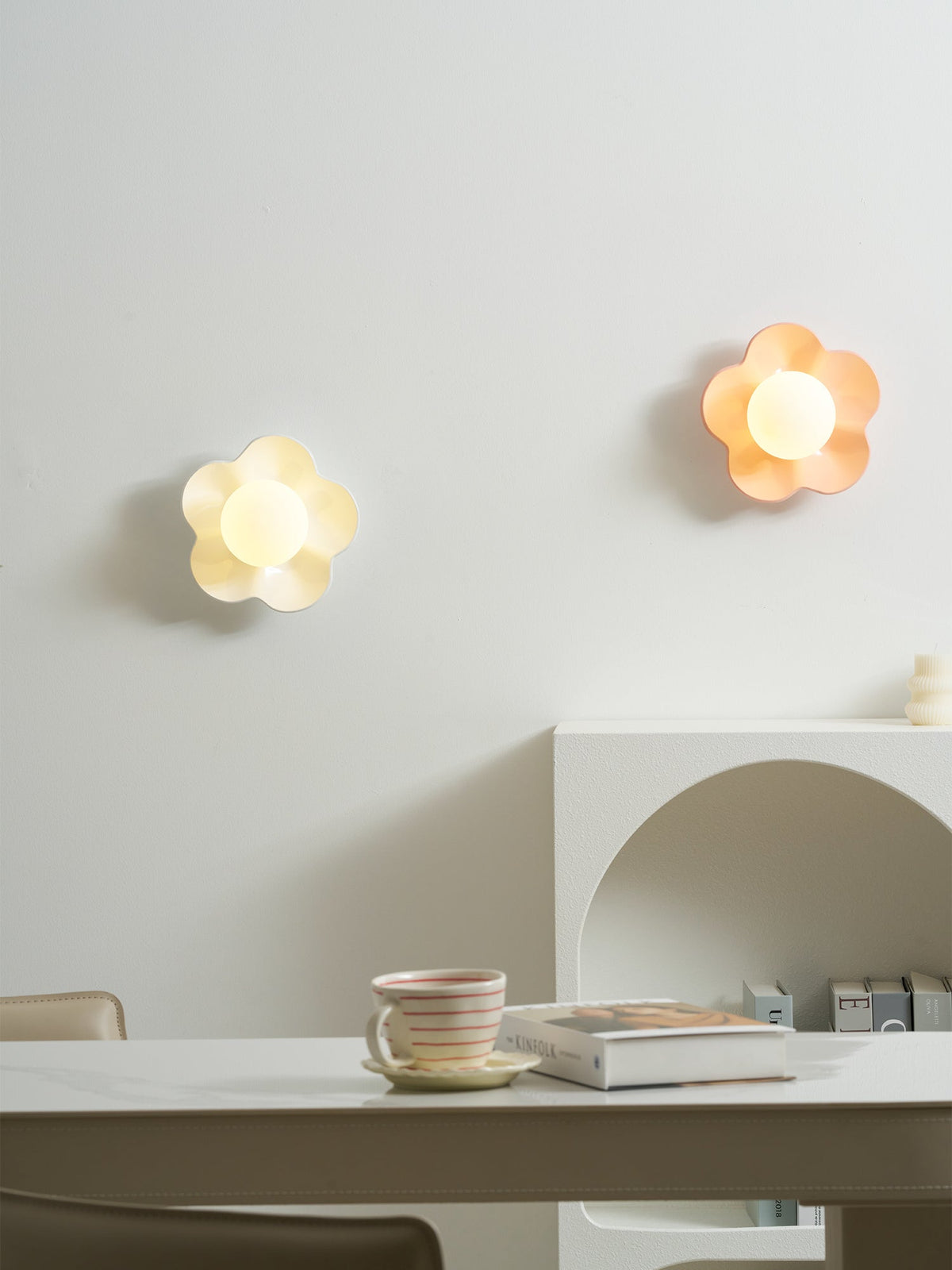 Two of these Clérachic wall lights, in white and pink, glow softly above the same console table.