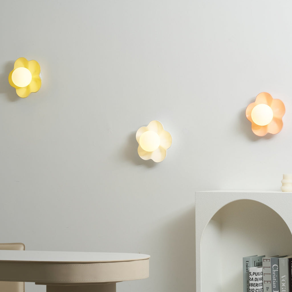 Three of these Clérachic wall lights are mounted in a row, in yellow, white and pink, two of them lit.