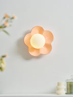 With flowers and a candle blurred in the foreground, this Clérachic wall light in pink glows on the wall.