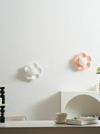 Two of these Clérachic wall lights, in white and pink, glow softly above a kitchen counter.