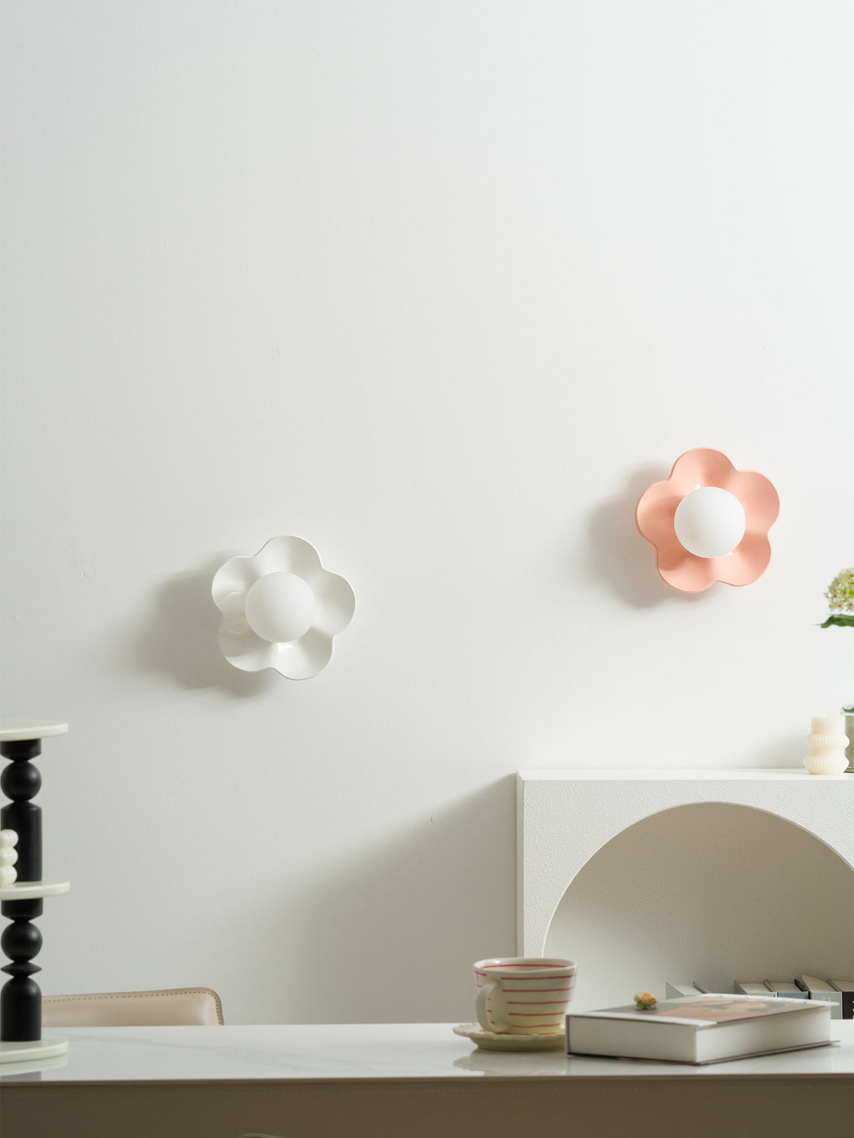 Two of these Clérachic wall lights, in white and pink, glow softly above a kitchen counter.