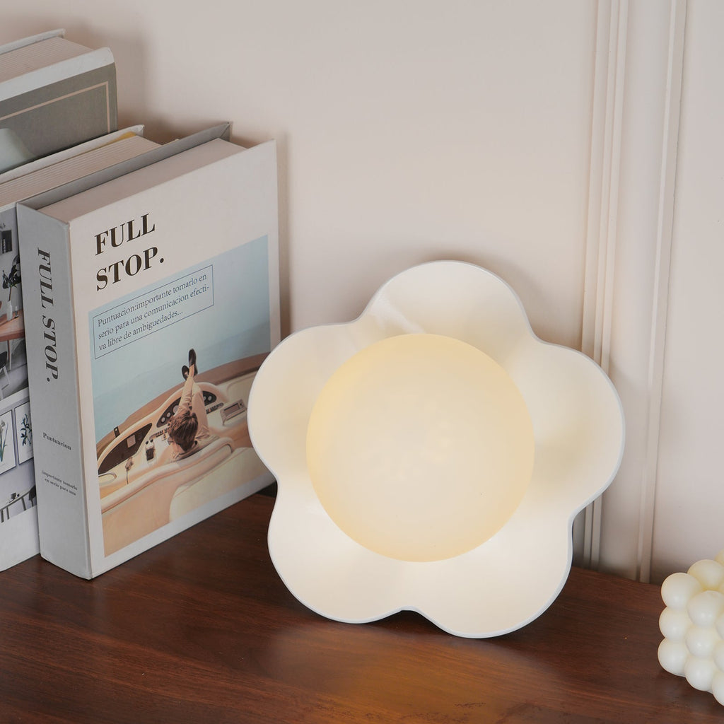 Resting on a stack of books titled "Full Stop", this Clérachic wall light in white sits unlit.