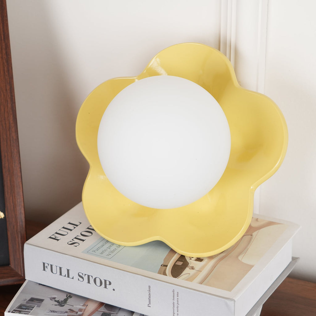 A close view of this Clérachic wall light in yellow, its ball unlit against the petals.