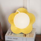 Its ball lit, this Clérachic wall light in yellow stands on a stack of books.