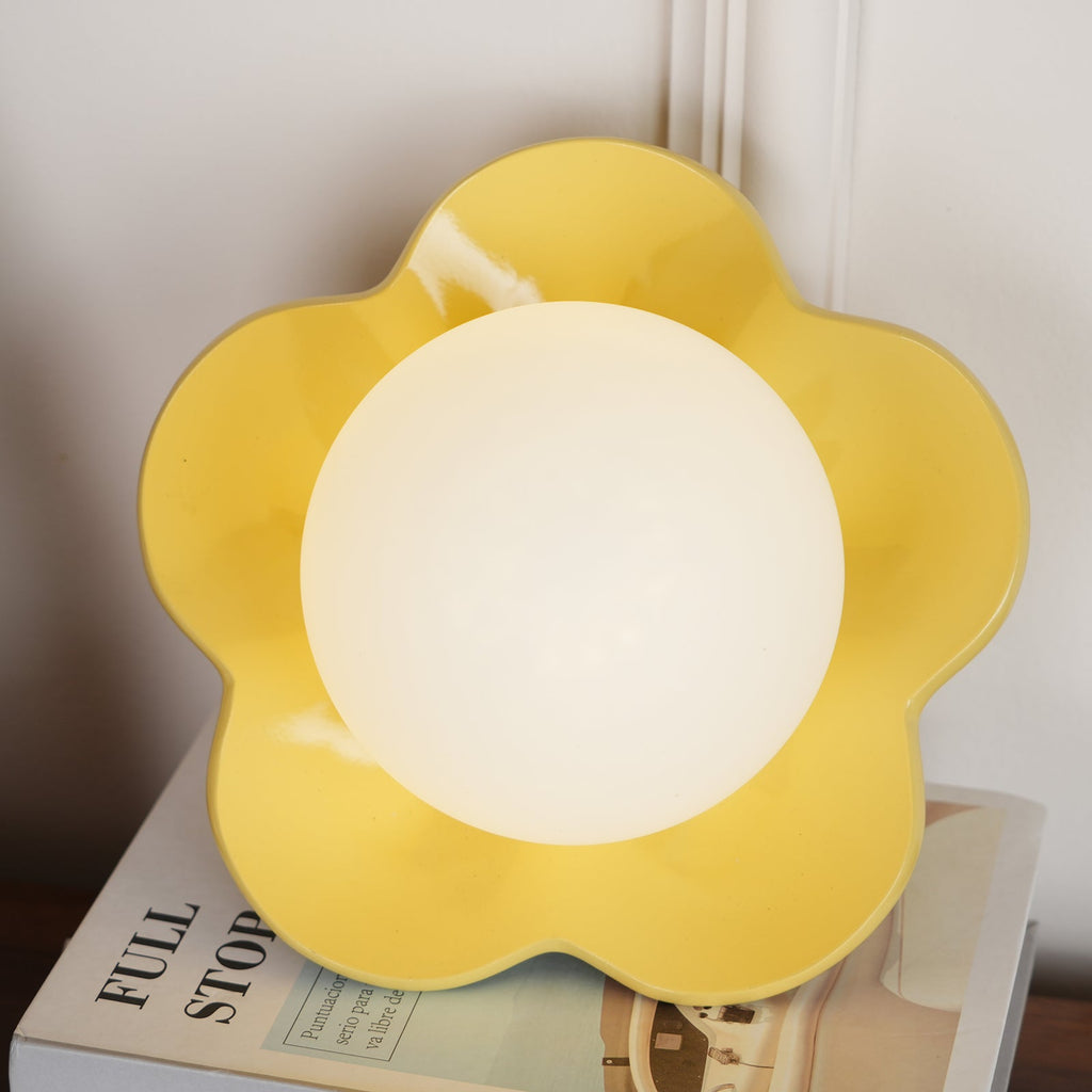 A close view of this Clérachic wall light in yellow with its ball lit, filling most of the frame.