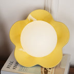 A close view of this Clérachic wall light in yellow with its ball lit, filling most of the frame.