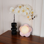 A second angle of this Clérachic wall light in pink beside the same black vase and orchid blooms.