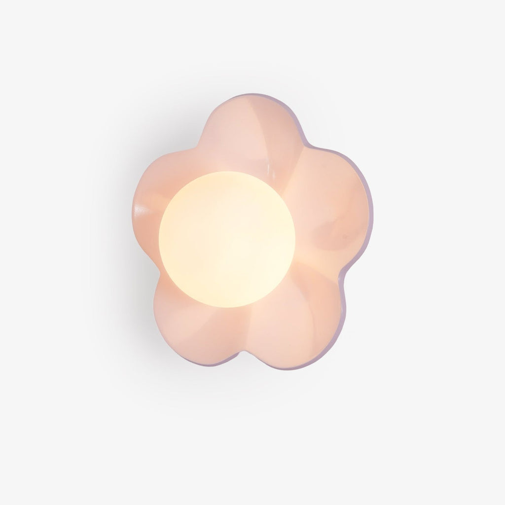 A close studio view of this Clérachic wall light in pink, its five petals framing the lit glass ball.