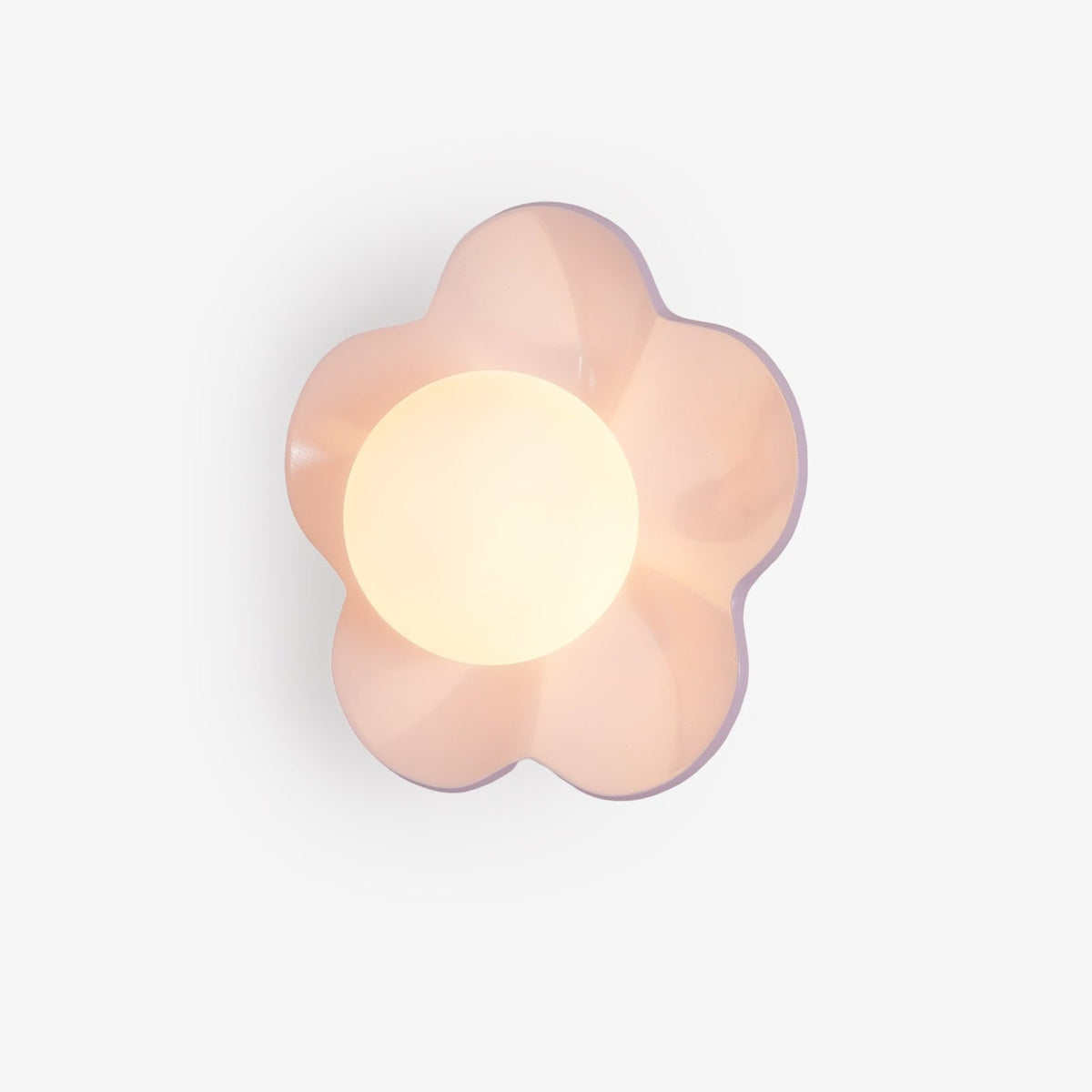 A close studio view of this Clérachic wall light in pink, its five petals framing the lit glass ball.