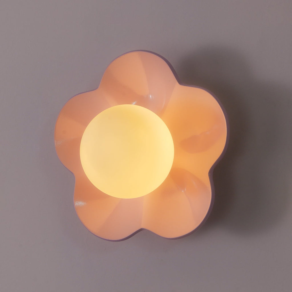 Shot straight on, this Clérachic wall light in pink sits unlit against a plain grey backdrop.