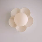Shot straight on, this Clérachic wall light in a blush tone sits unlit against a lavender-grey backdrop.