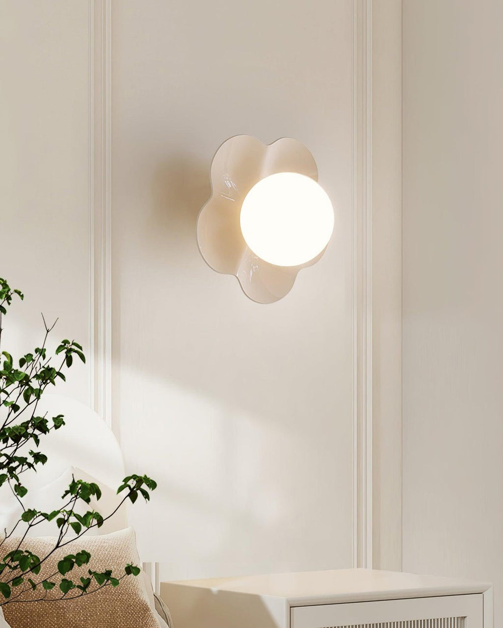 With a plant visible in the lower corner, this Clérachic wall light in white sits mounted on the wall.
