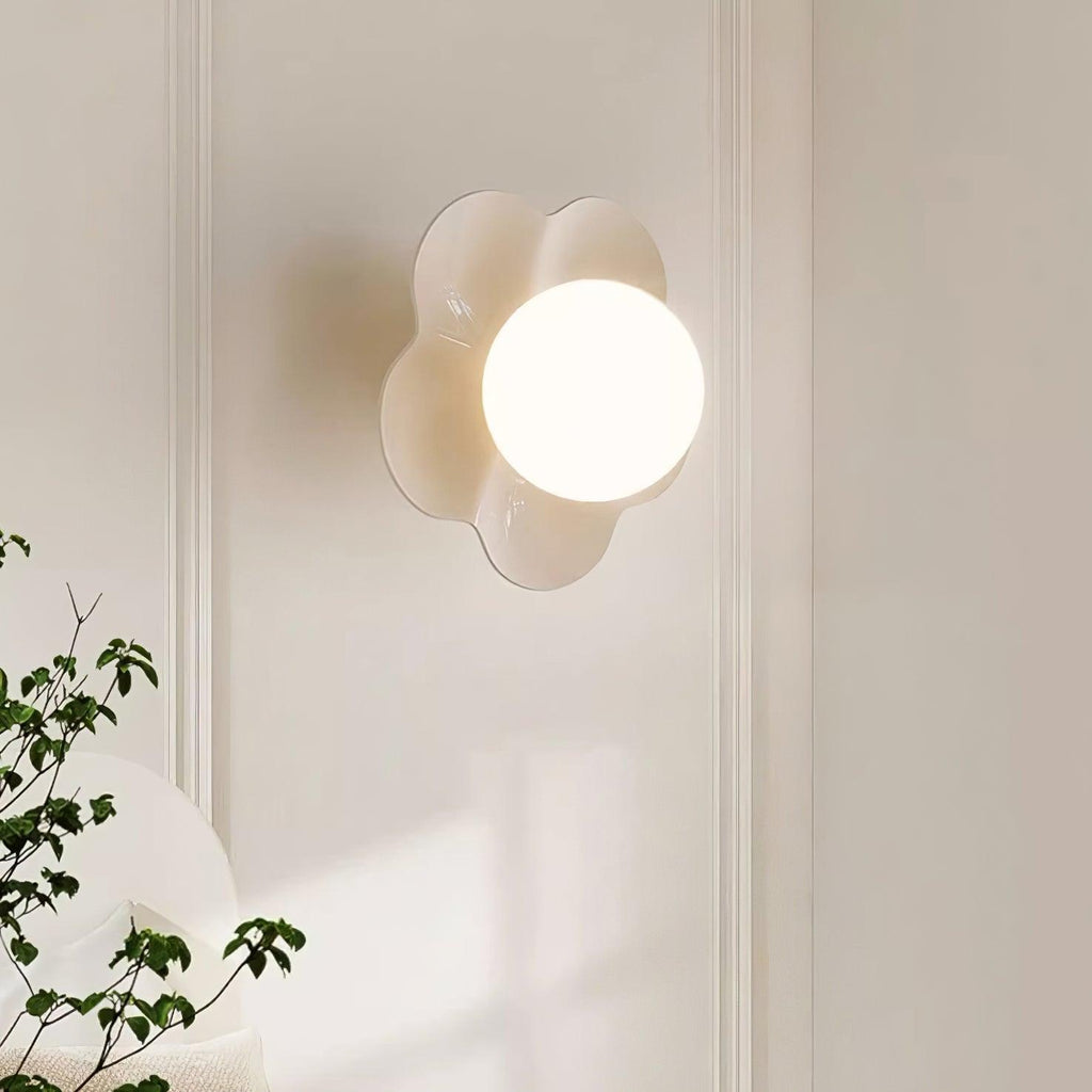 On a plain wall with a plant at its base, this Clérachic wall light in white sits mounted.