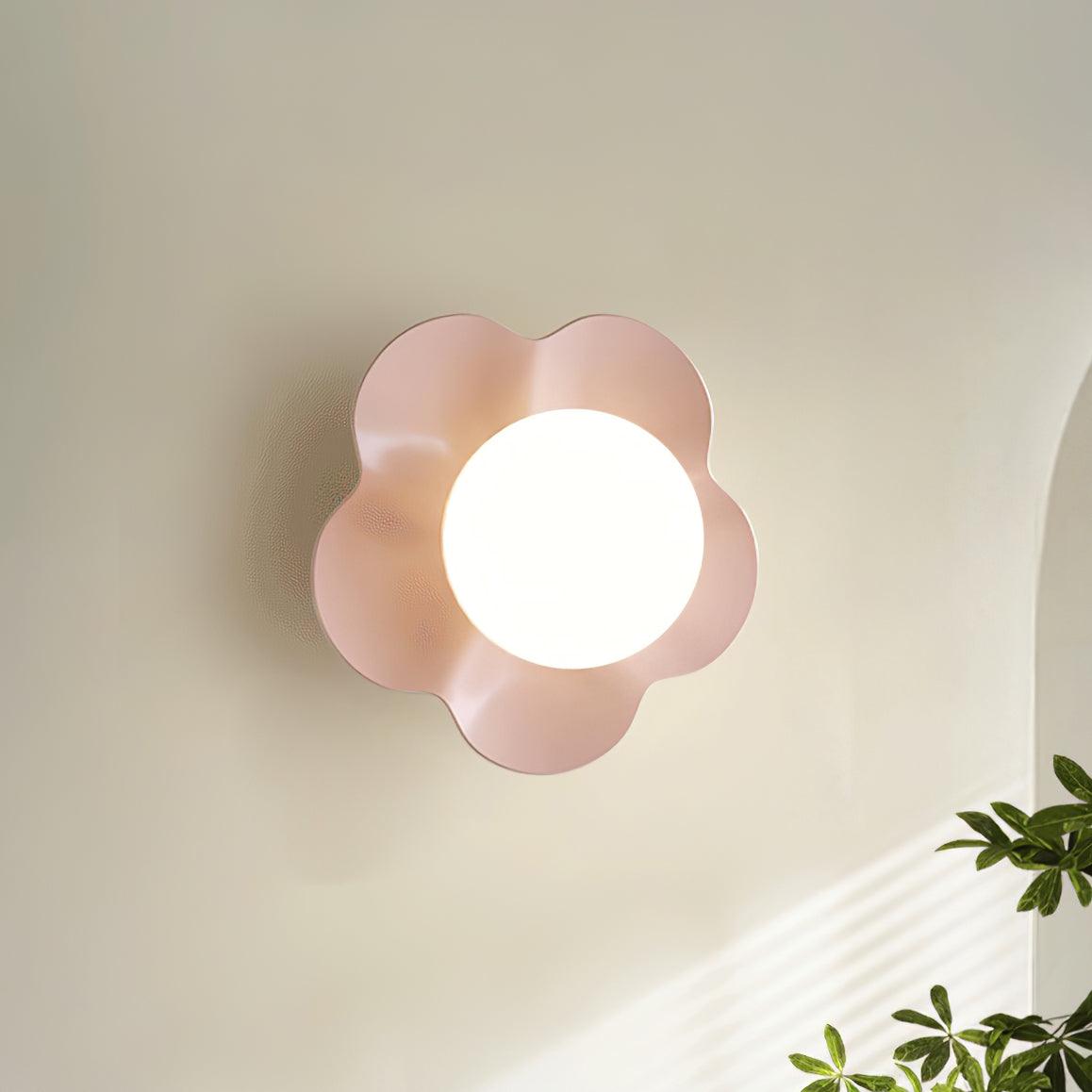 Near an archway with a plant in the foreground, this Clérachic wall light in pink is mounted on the wall.