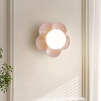 Mounted beside a sunlit window with a plant below, this Clérachic wall light in pink softens the corner.